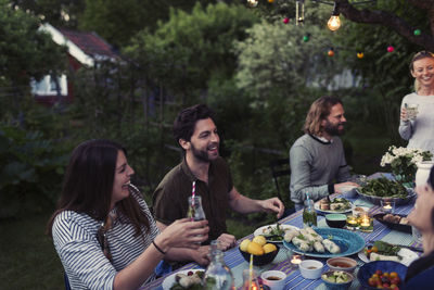 Happy friends enjoying dinner party at yard