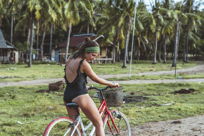 Young woman riding bicycle on field