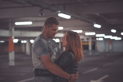 Couple embracing in parking lot