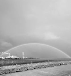 Scenic view of sea against rainbow in sky