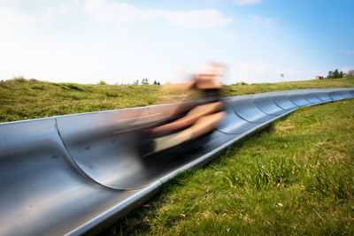 Blurred motion of man on ride against sky