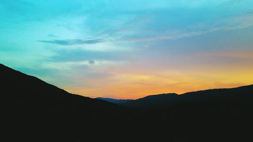 Scenic view of silhouette mountains against sky at sunset