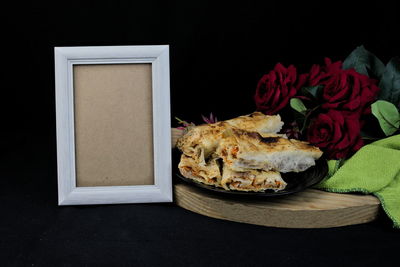 Close-up of roses on table against black background