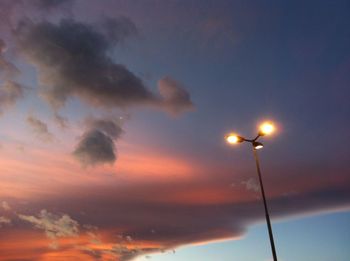 Low angle view of illuminated street light against sky at sunset