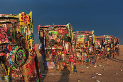 Graffiti on metallic structure at beach against sky