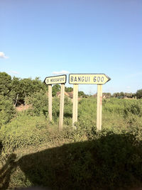 Information sign on field against sky