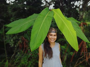 Portrait of smiling woman standing against plants