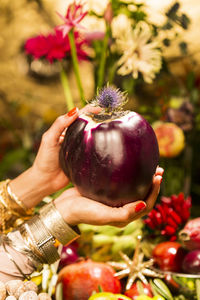 Close-up of hand holding red berries in basket