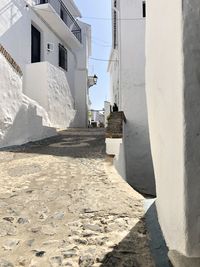 Footpath amidst buildings against sky