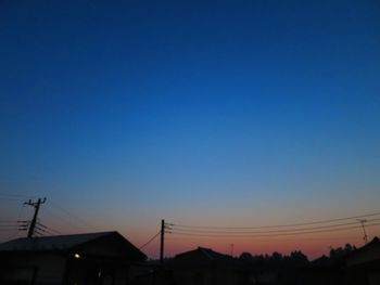 Low angle view of silhouette houses against clear sky