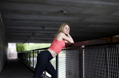 Side view of woman leaning on railing