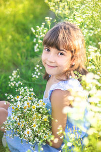 Smiling girl sitting amidst flowers