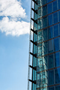 Low angle view of glass building against sky