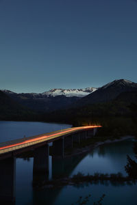 Faller-klamm-bridge over lake sylvenstein against sky during sunset