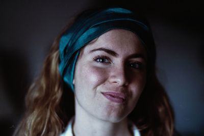 Close-up portrait of smiling young woman wearing blue head scarf