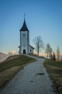 Church amidst buildings against clear sky