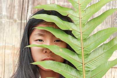 Portrait of a smiling young woman holding leaf