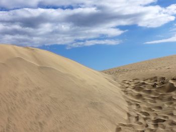 Sand dunes in desert against sky