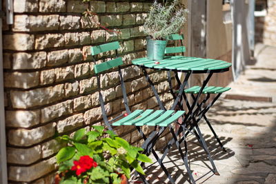 Empty chairs and table against wall