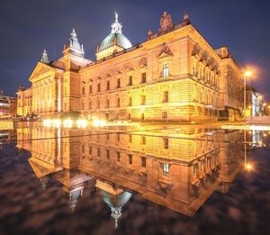 Reflection of illuminated building in water at night