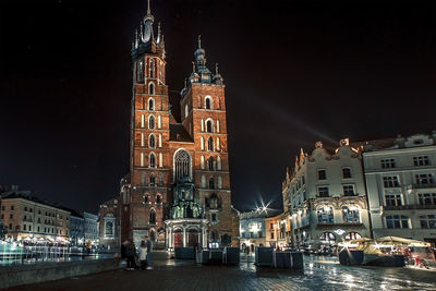 Krakow old night illuminated square and mariacka cathedral, rynek glowny, poland, stare miasto