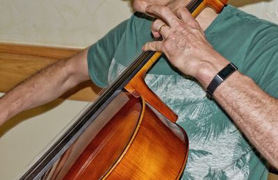 Midsection of man playing cello
