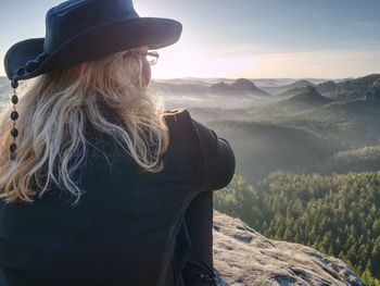 Woman hiker with leather hat conquer highest peak. woman hiker traveling alone. hipster hiker style.