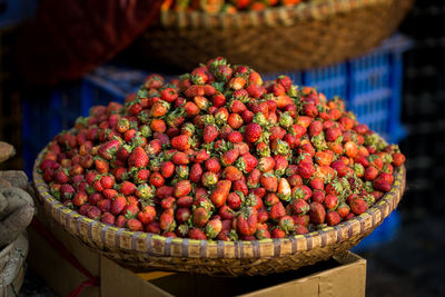 Strawberries in wicker basket at market for sale