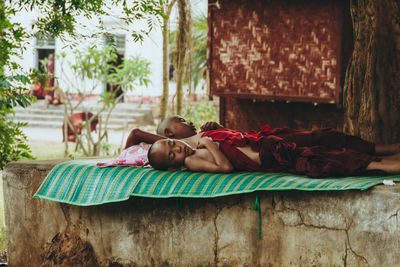 Rear view of mother with baby sleeping on floor