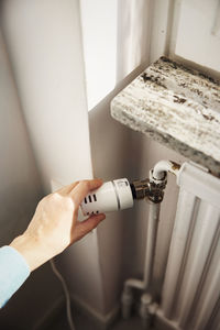 Woman adjusting radiator temperature