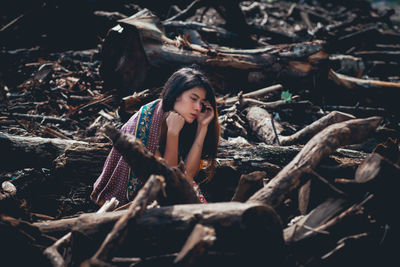 Portrait of woman with log in forest