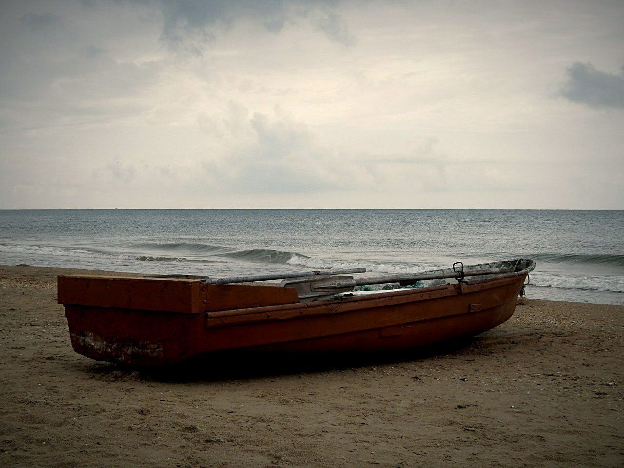 sea, nautical vessel, water, horizon over water, transportation, boat, beach, mode of transport, moored, sky, shore, sand, tranquil scene, tranquility, beauty in nature, nature, scenics, travel, outdoors, idyllic