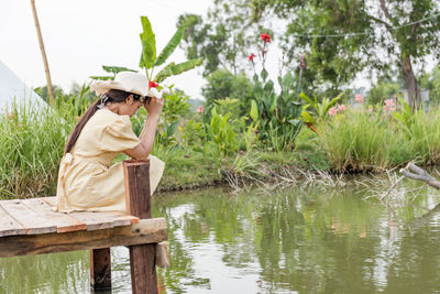 Side view of senior man sitting by lake