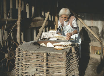 Woman sitting in basket on table