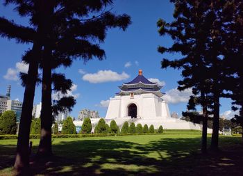 View of trees and building against blue sky