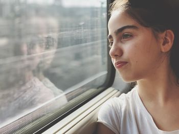 Woman looking through window sitting in train