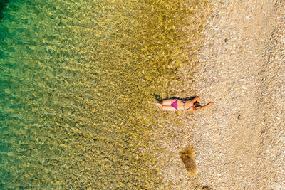 High angle view of woman lying on beach