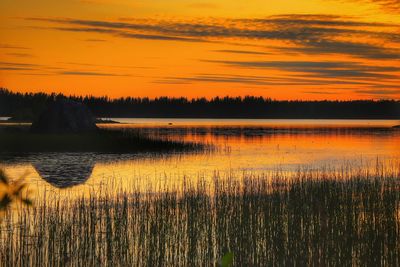 Scenic view of lake against orange sky