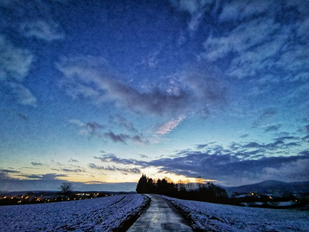 ROAD LEADING TOWARDS SNOWCAPPED MOUNTAIN AGAINST BLUE SKY