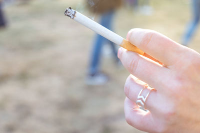 Close-up of hand holding cigarette