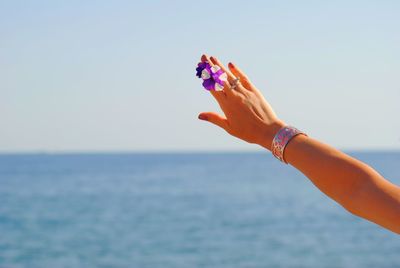 Midsection of woman holding sea against sky