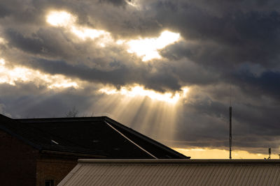 Low angle view of roof and building against sky during sunset