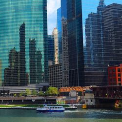 Modern cityscape by river against sky