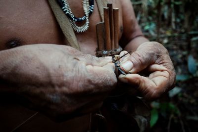 Midsection of indigenous man holding equipment