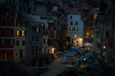 Cars on illuminated street amidst buildings in city at night