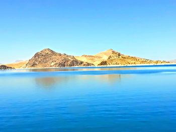 Scenic view of sea against clear blue sky