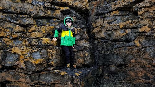 Portrait of boy standing on rock formation