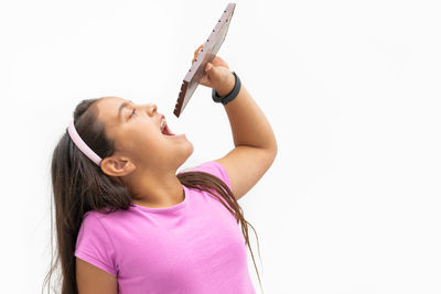 Low angle view of girl looking at camera over white background