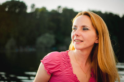 Portrait of smiling young woman looking away outdoors