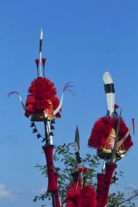 Low angle view of red light against blue sky